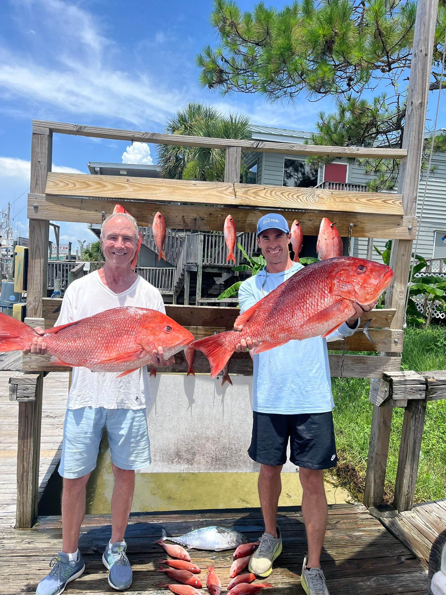 Red snapper fishing success in Destin FL with multiple large red snapper displayed at cleaning station