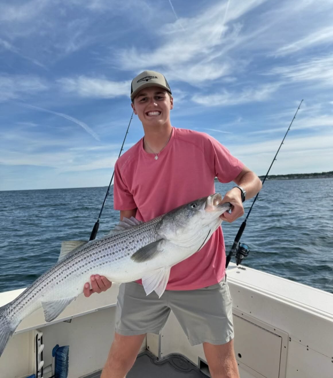 Striped bass fishing charter boat in Wells Maine waters with angler holding catch