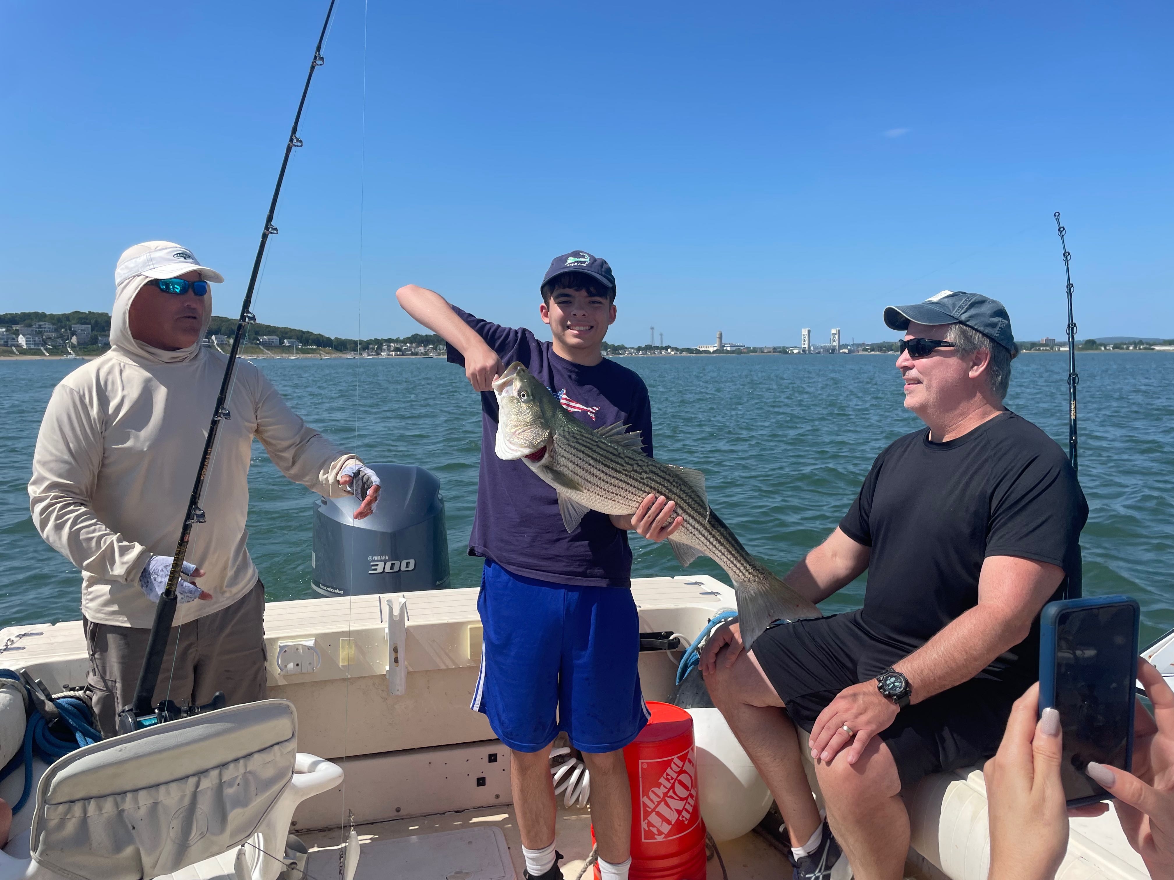 Striped bass caught during fishing charter in Hingham MA with three anglers on boat
