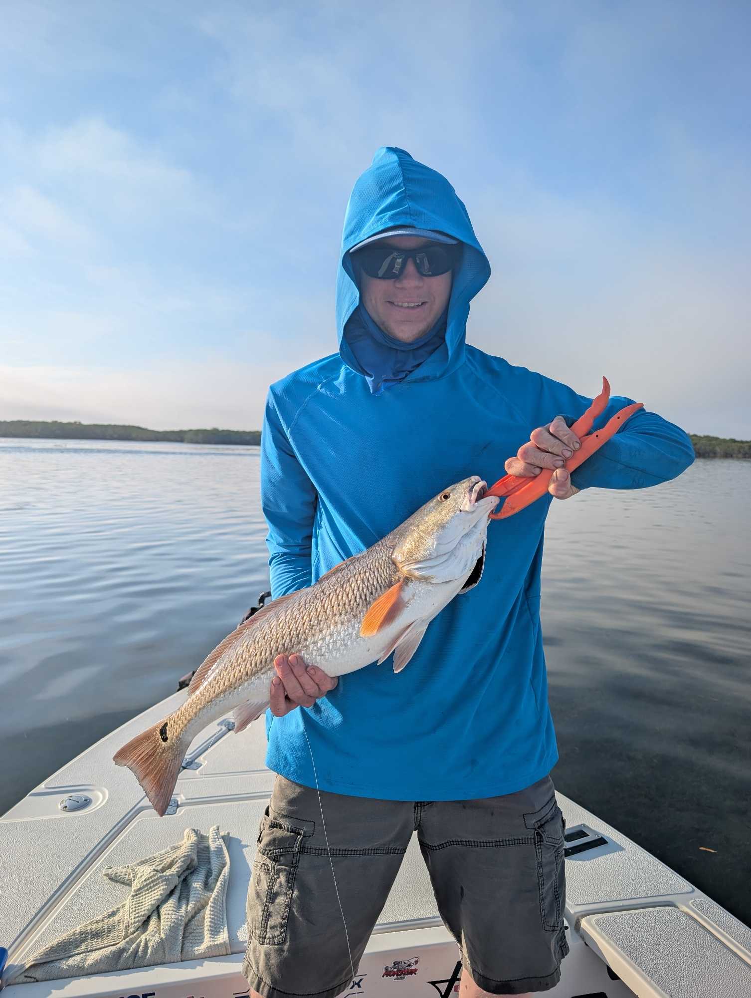 Angler holding caught redfish on fishing boat in Crystal River FL