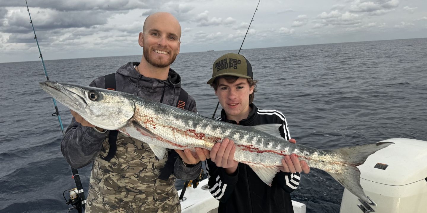 A fisherman holding a great barracuda fish in FL