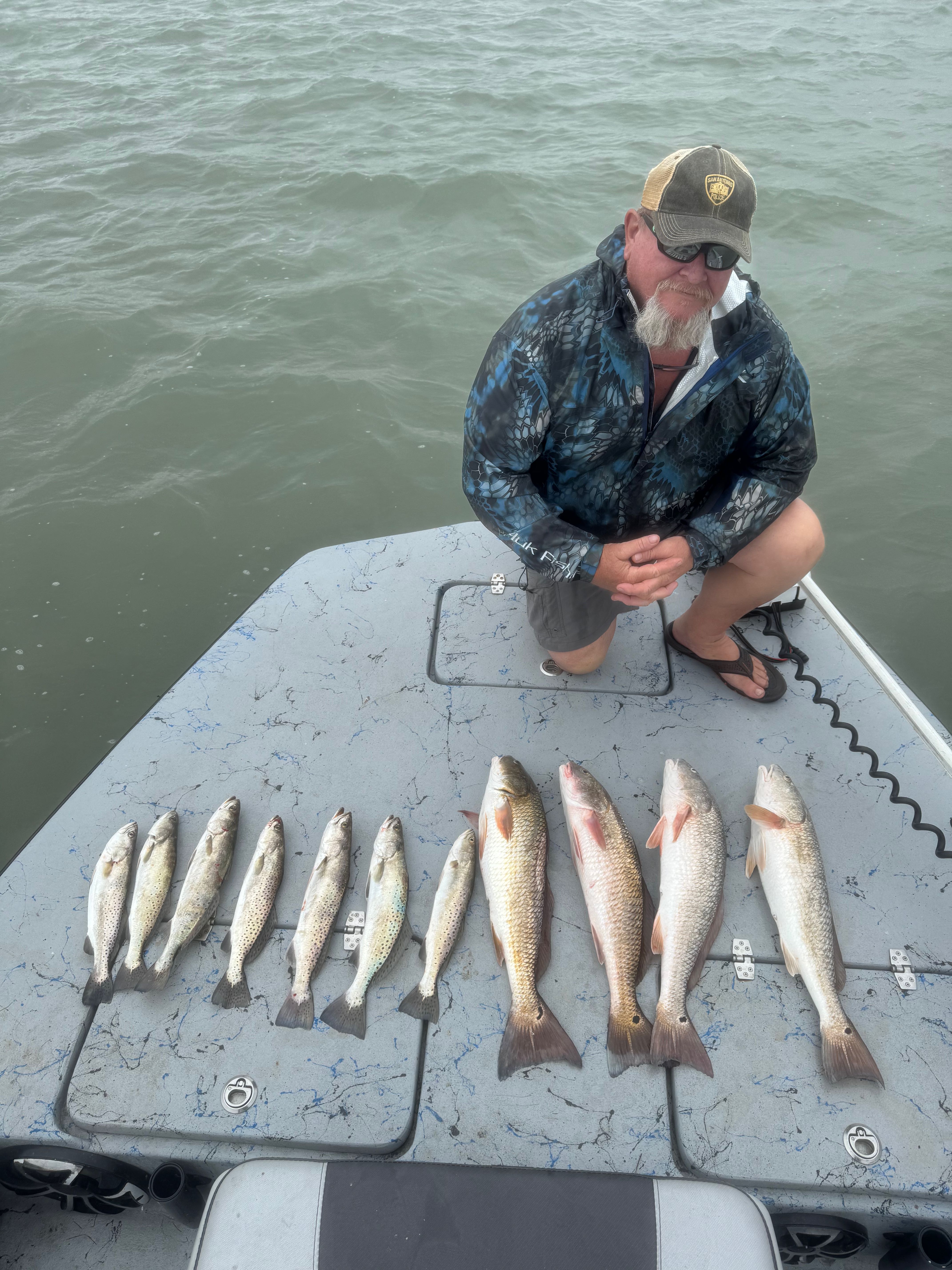 Successful fishing trip showing redfish and speckled trout catch laid out on boat deck in Pleasanton TX