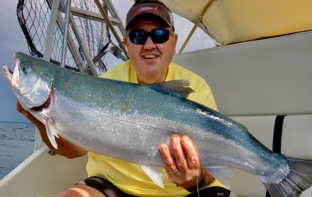 Angler reeling in a 30-inch fish during a cruise in North Muskegon