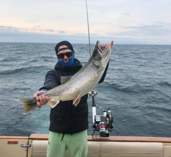 Angler holding a large rainbow trout in MI