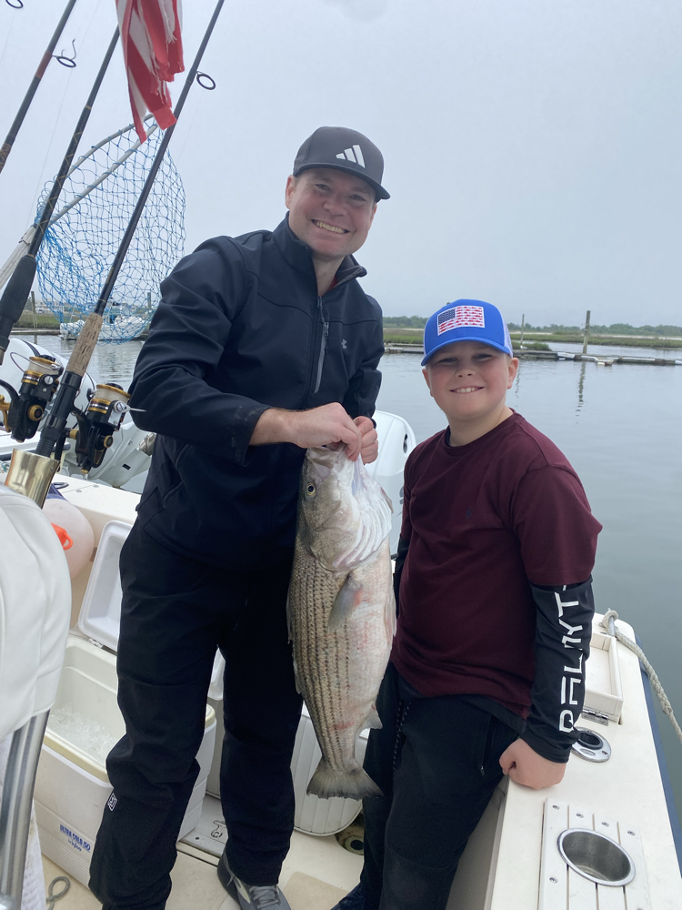 Striped bass fishing success in Barnegat Light NJ with freshly caught fish displayed on charter boat