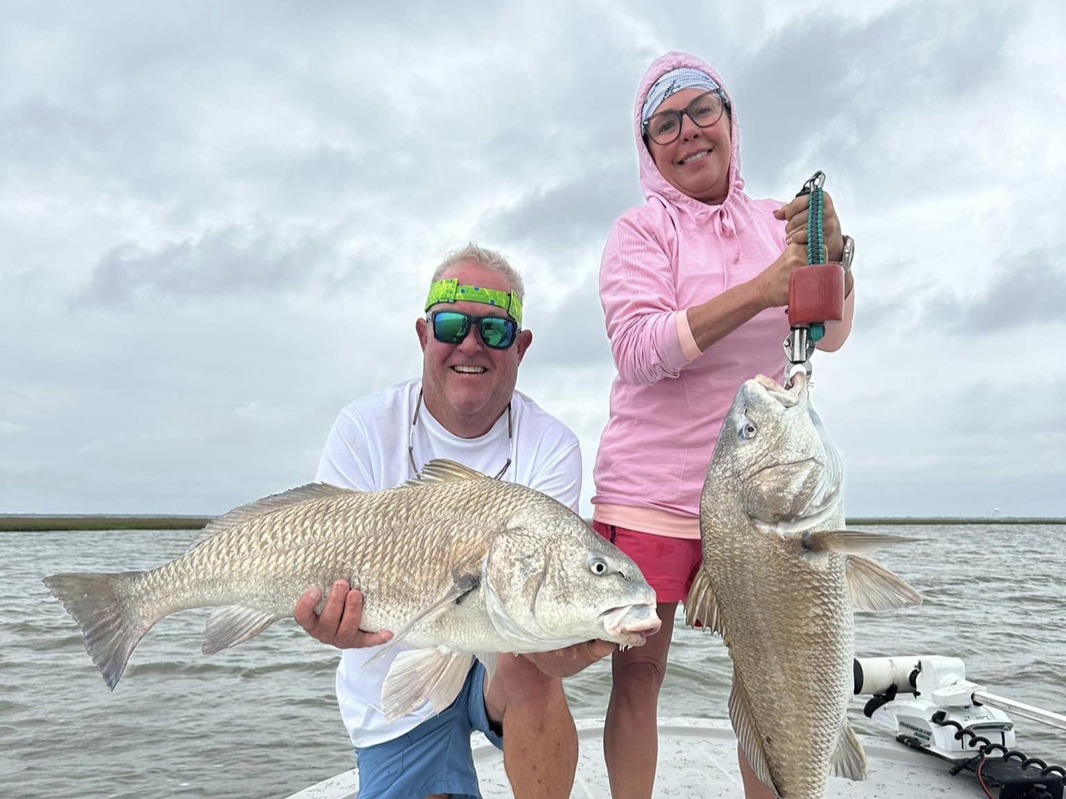 Two anglers with two large black drum fish at Tiki Island