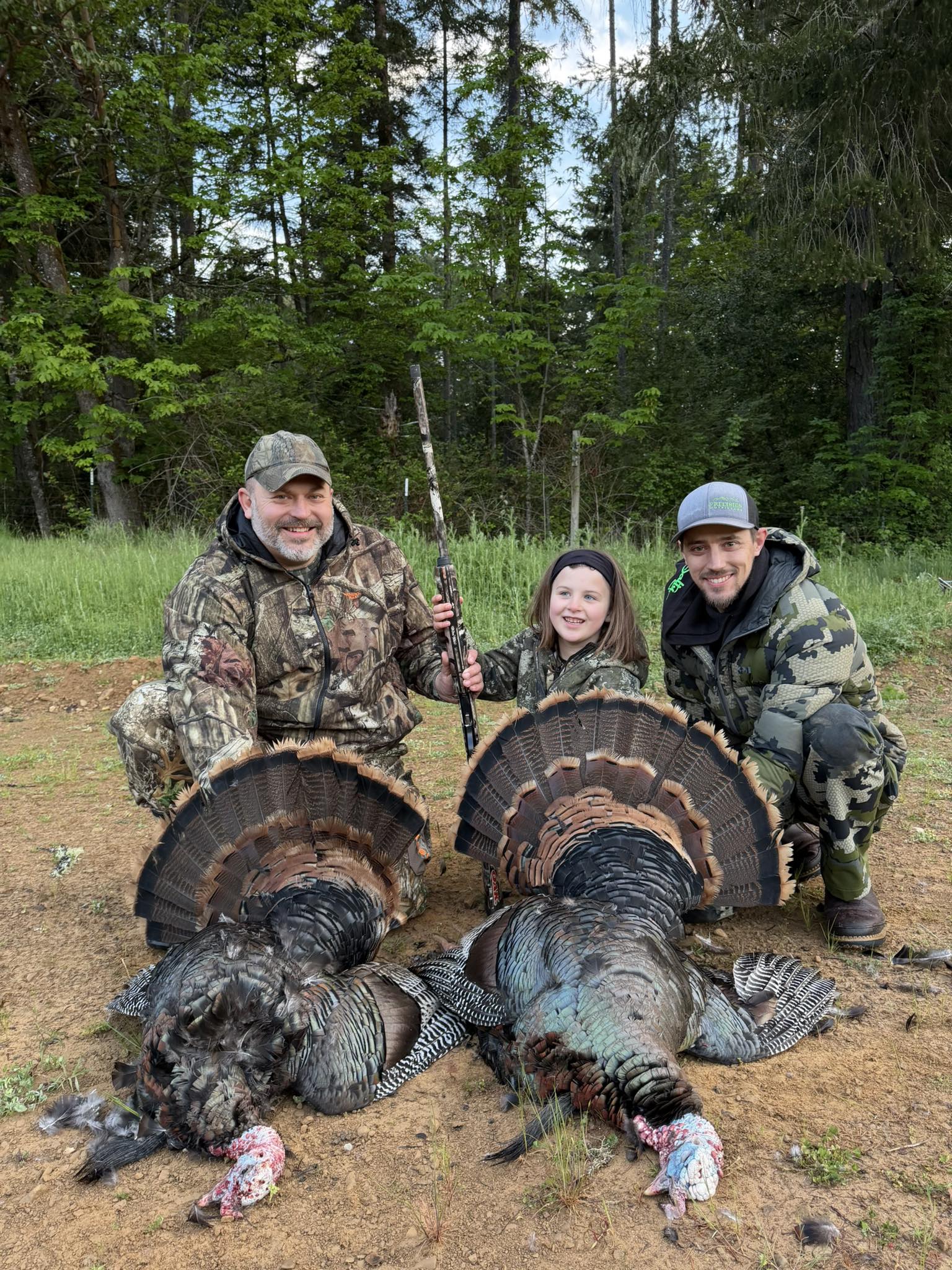Two wild turkeys harvested during hunting trip in Winchester Bay OR with tail feathers displayed