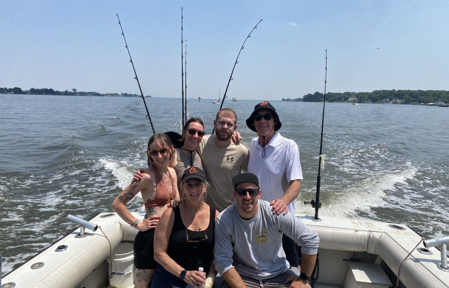 Fishing charter group on boat with multiple fishing rods in Baltimore MD waters