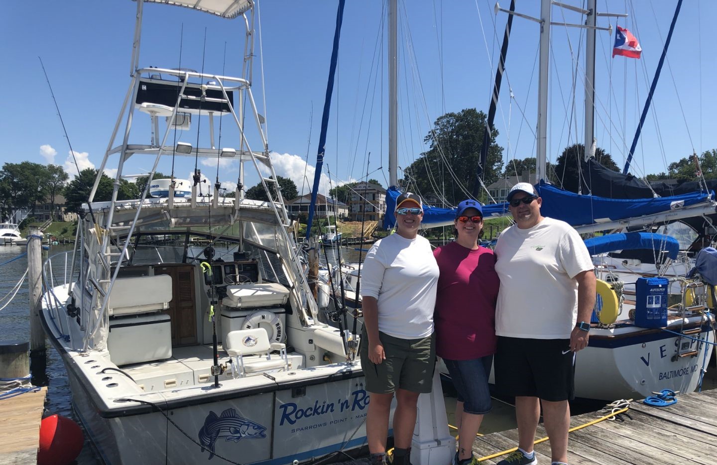 Fishing charter boat docked at marina in Baltimore MD with fishing equipment and outrigger poles