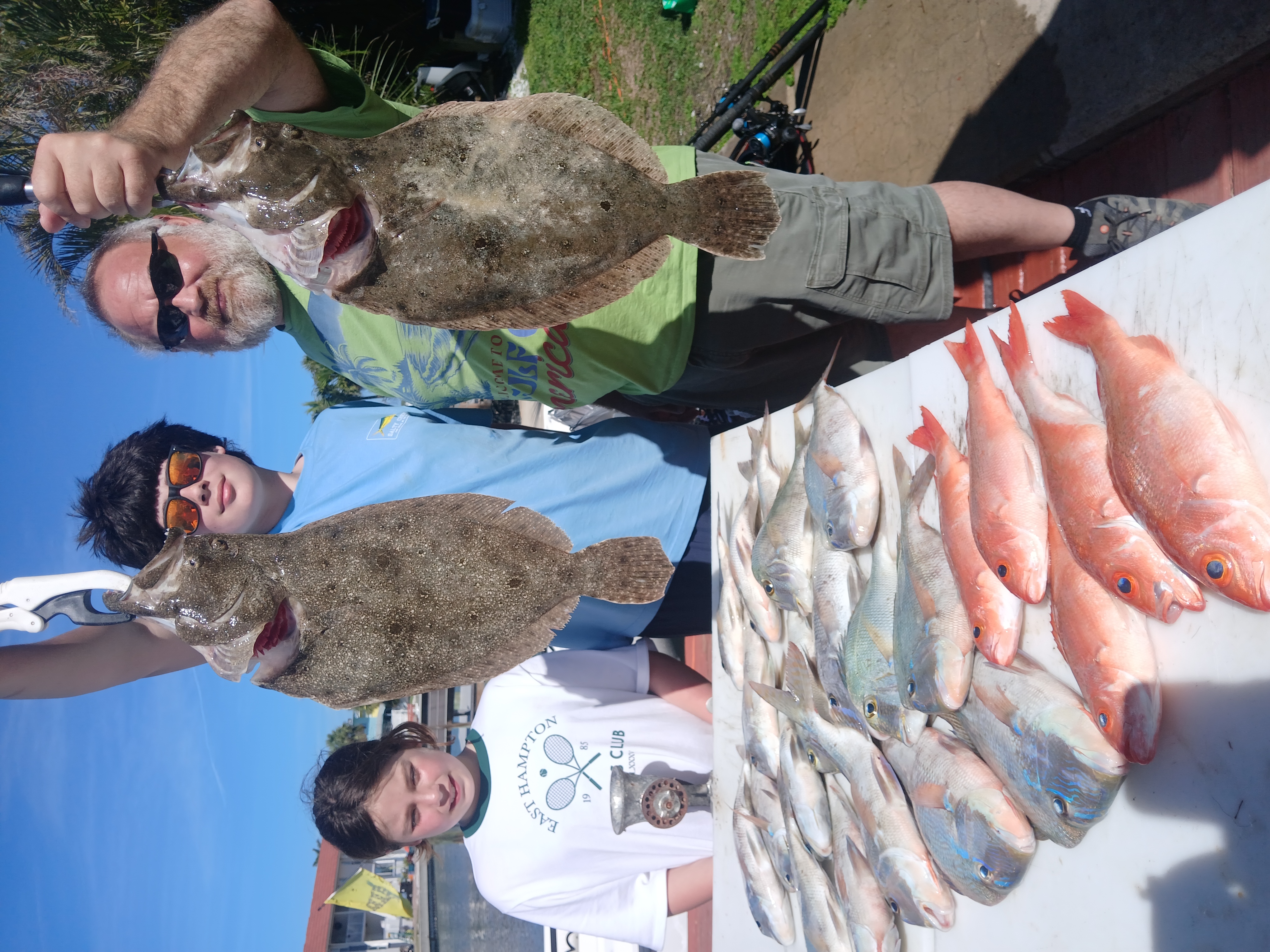 A group of 4 people with 6 summer flounder fish on Treasure Island