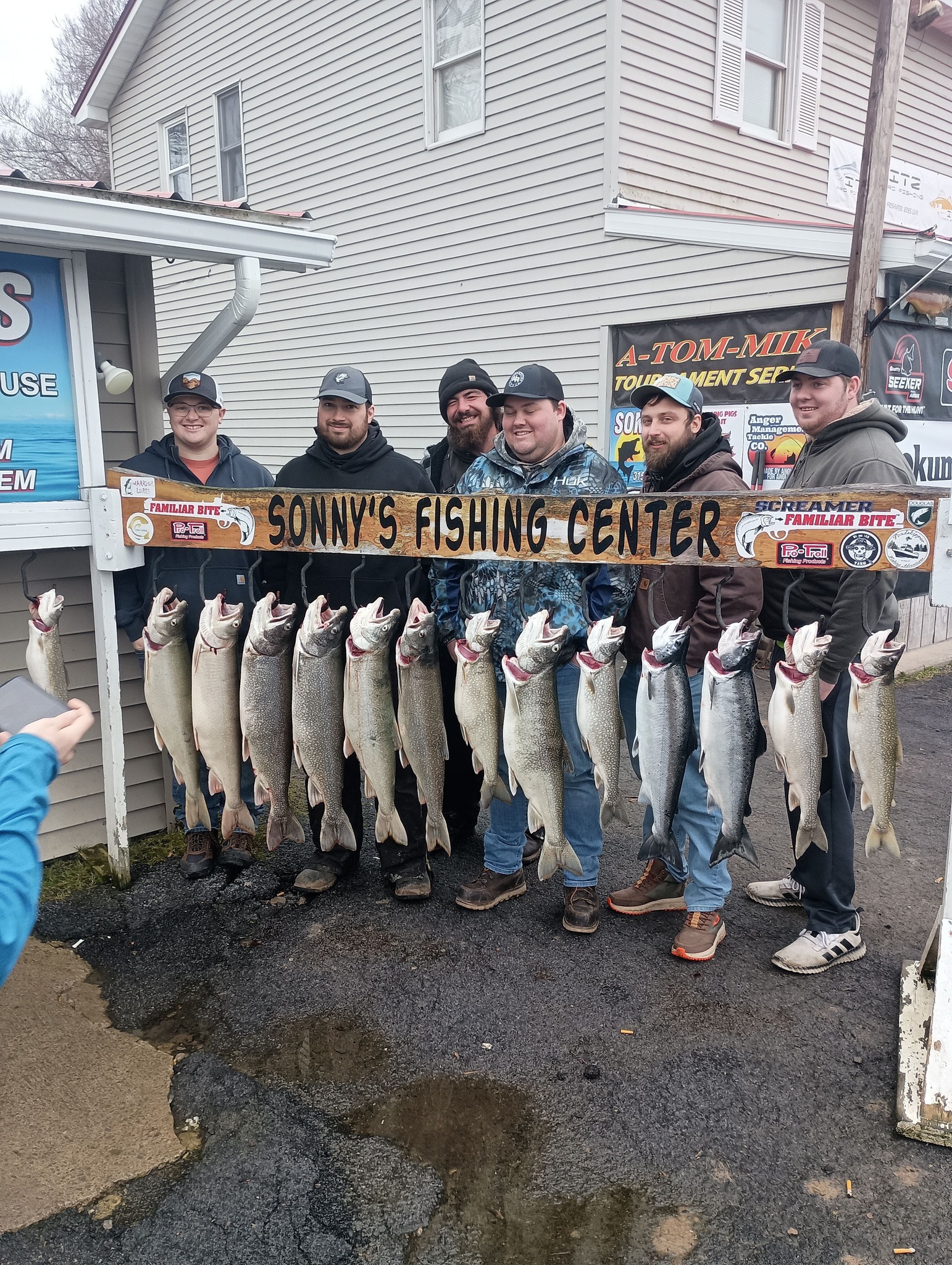 Successful fishing trip displaying multiple lake trout and coho salmon caught in Pulaski NY at fishing center