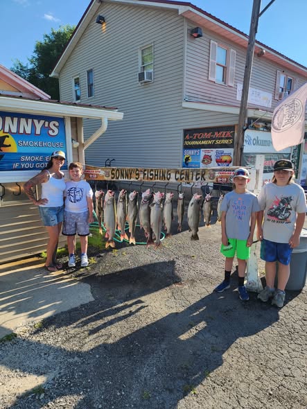 Successful salmon fishing trip display at Sonny's Fishing Center in Pulaski NY with multiple caught salmon hanging on rack