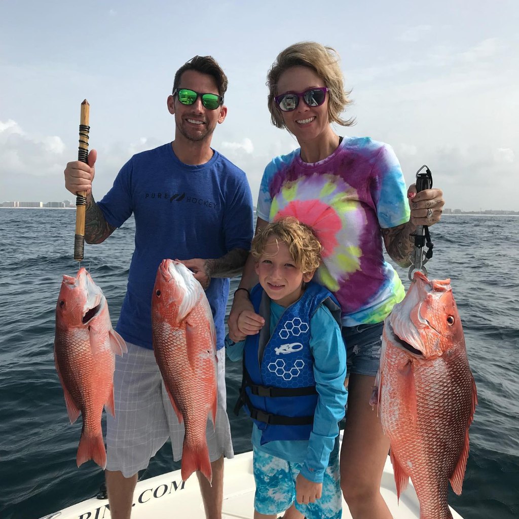 Three anglers holding large fish catch in Fort Walton Beach