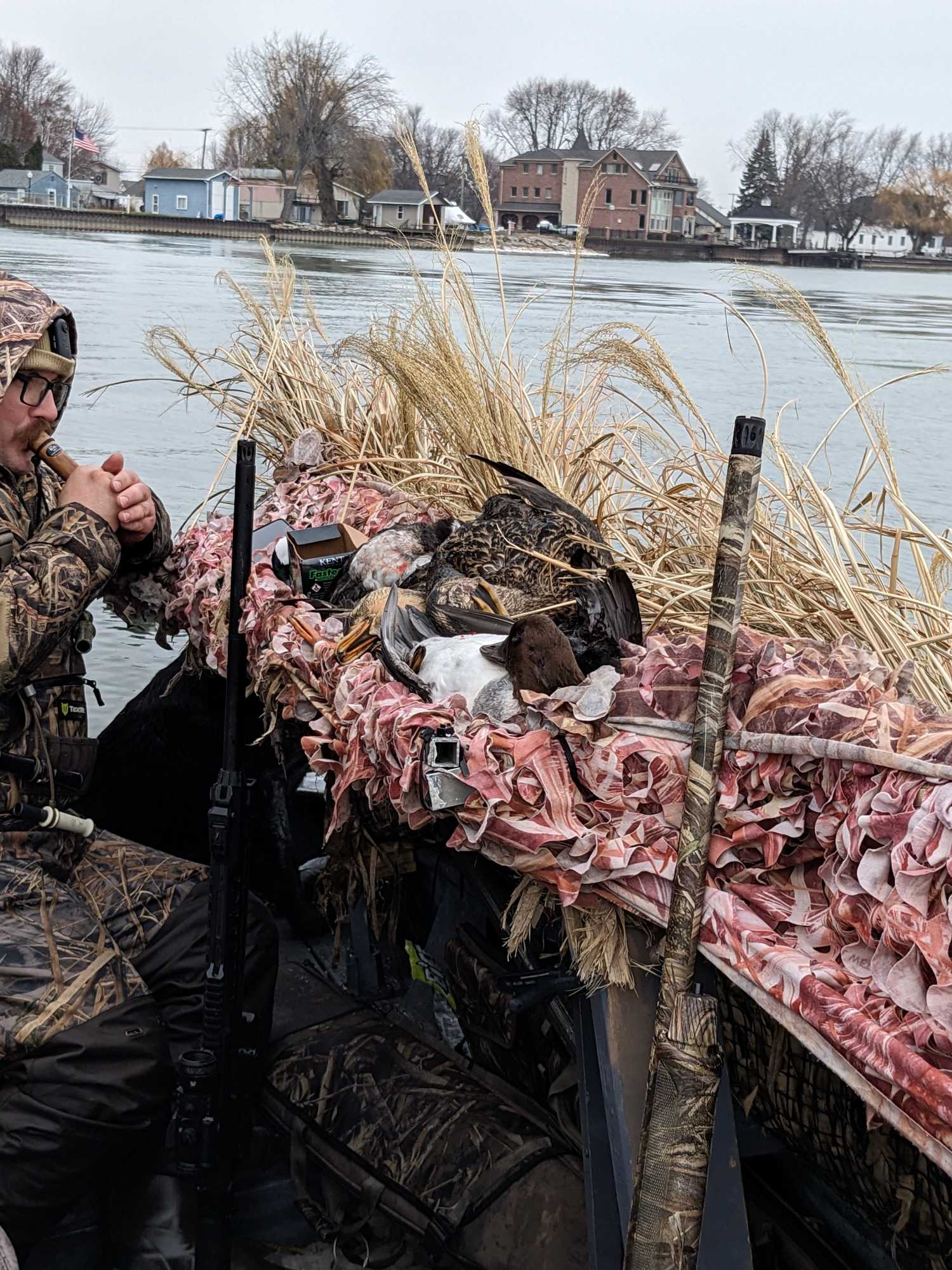 Duck hunting boat with camouflage setup and decoys on water in Detroit MI