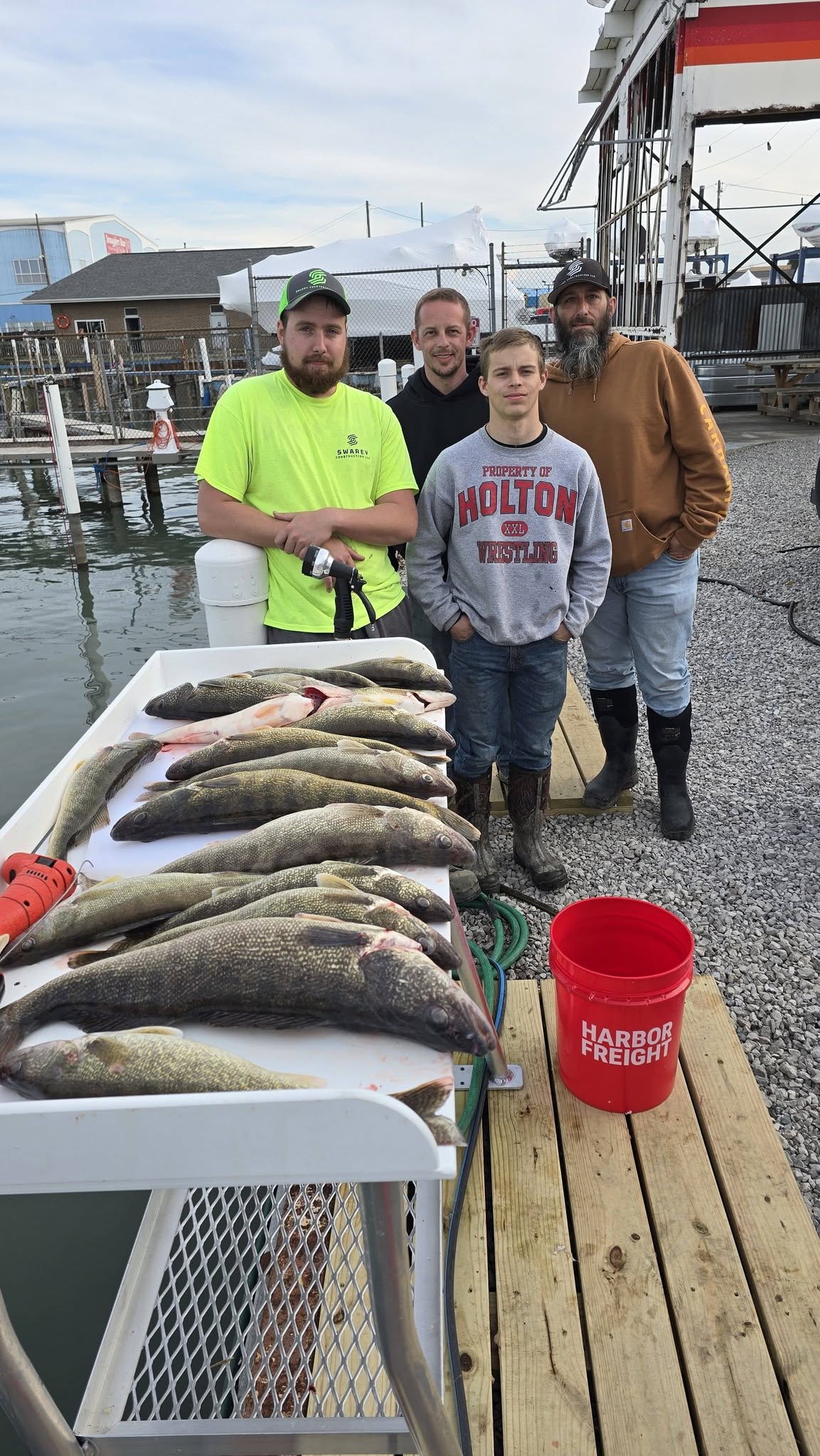 Successful walleye fishing trip in Whitehall MI with multiple fish displayed on cleaning table at marina