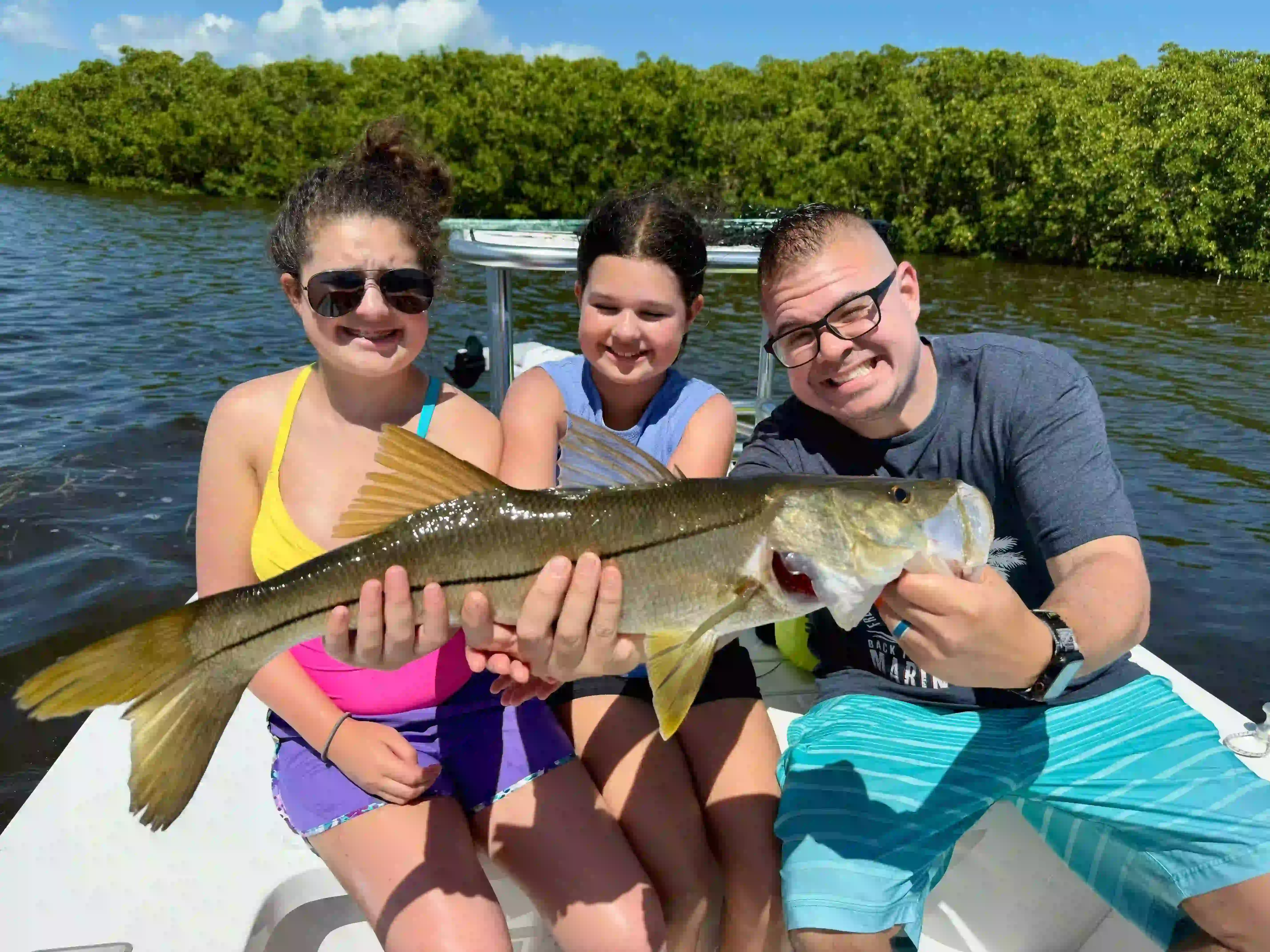Clearwater inshore fishing charter boat with anglers catching redfish, snook and trout