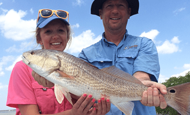 Two people fishing in Florida with a 20-inch fish
