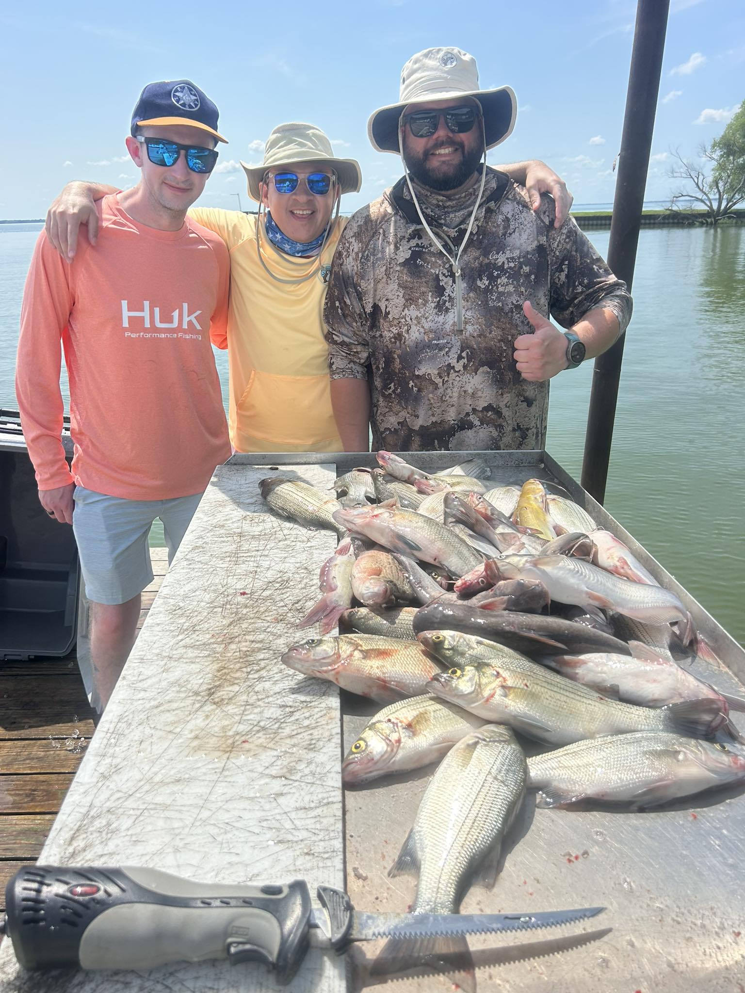 Successful white bass fishing trip in Quinlan TX with large catch displayed on cleaning table