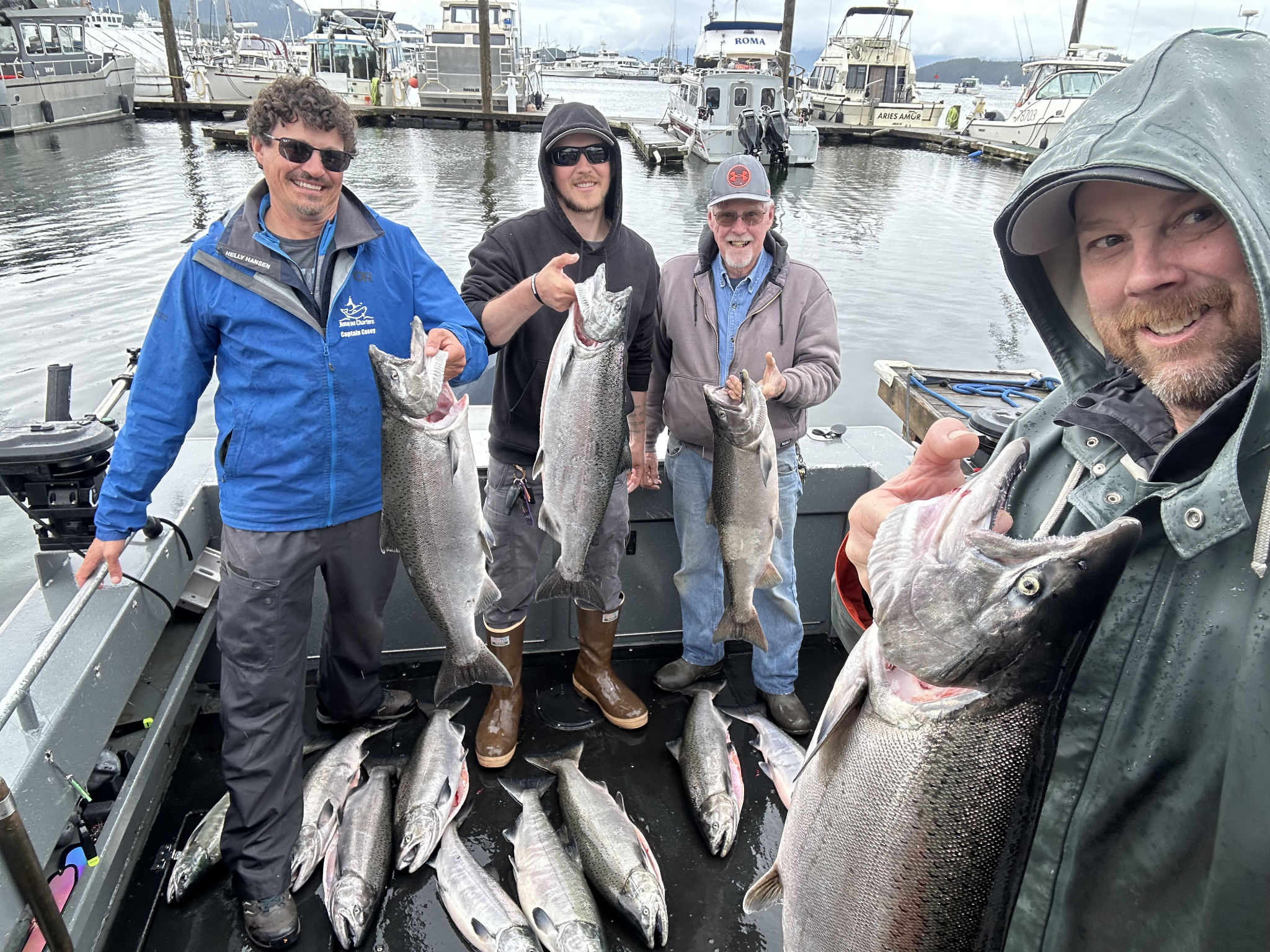 Successful fishing trip in Juneau Alaska with fresh caught Coho and Chinook salmon displayed on boat deck at marina