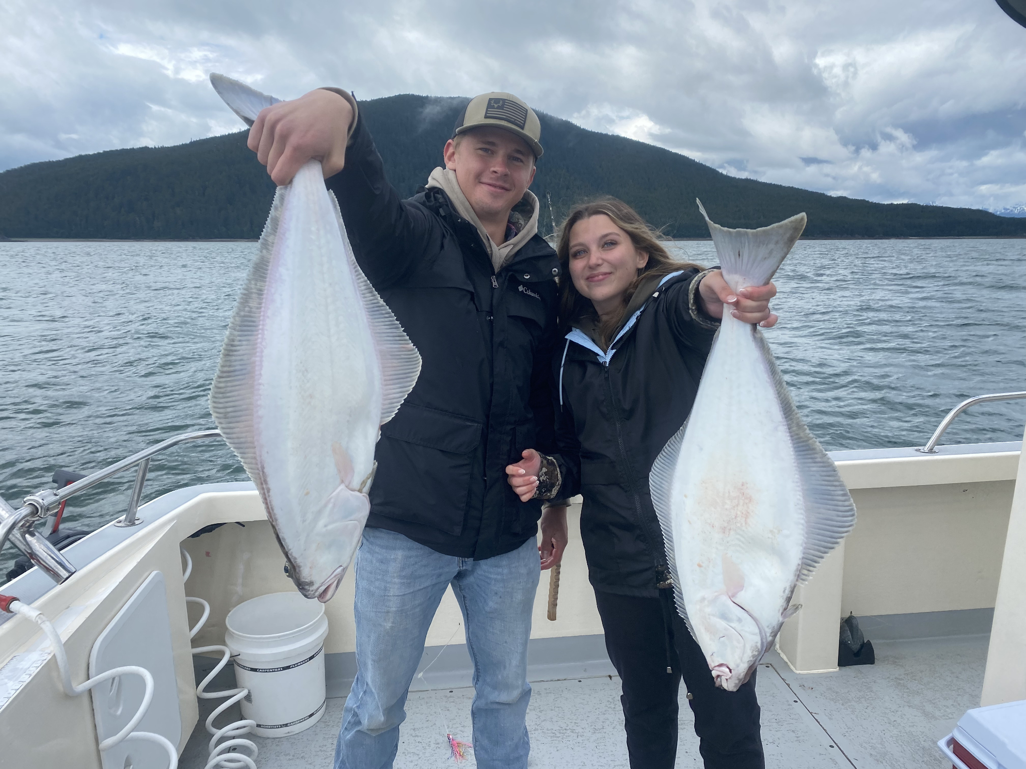 Two large Pacific halibut caught while fishing in Juneau Alaska waters displayed on boat deck
