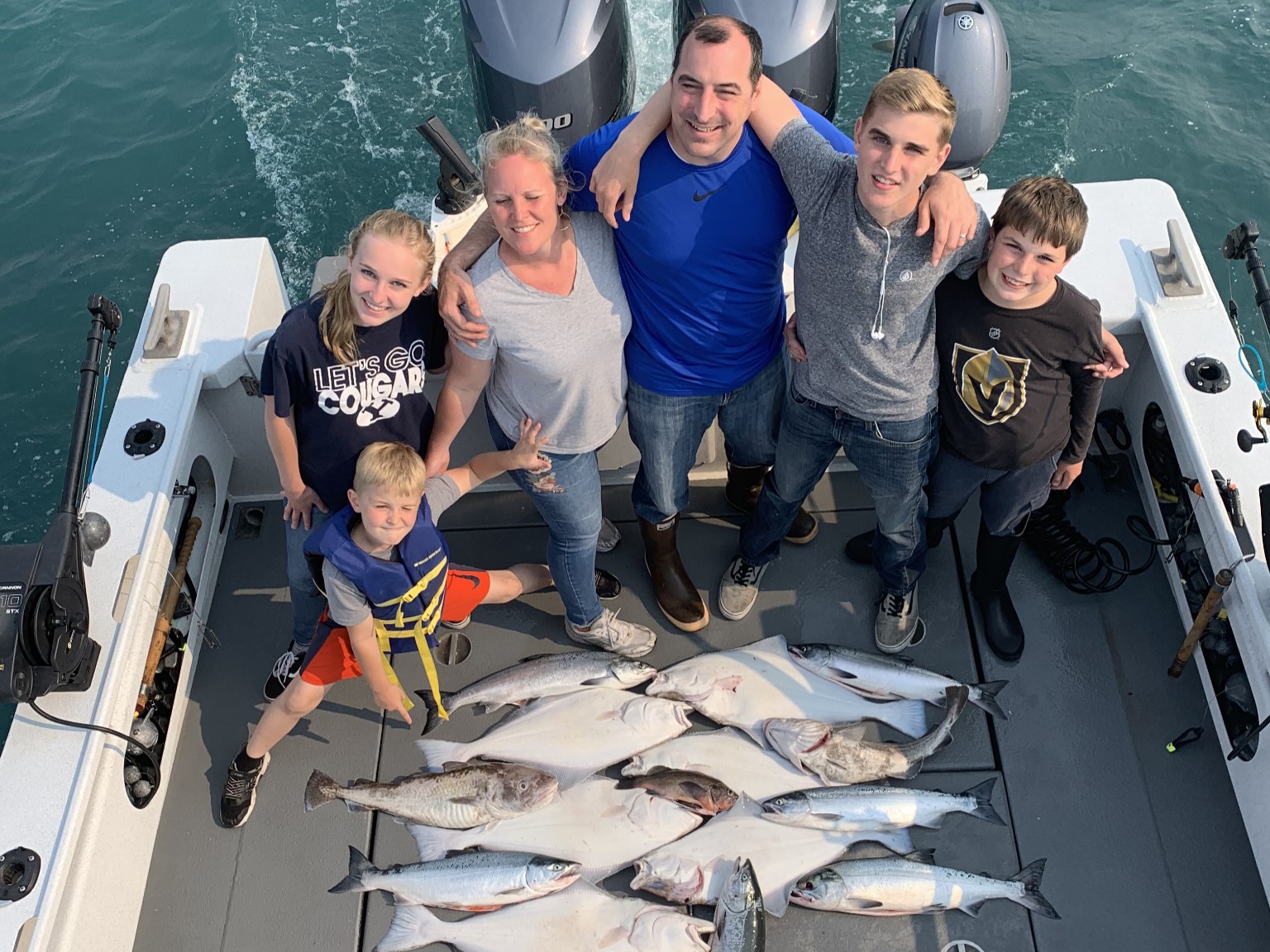 Salmon halibut fishing charter boat in Juneau Alaska waters with anglers and mountains
