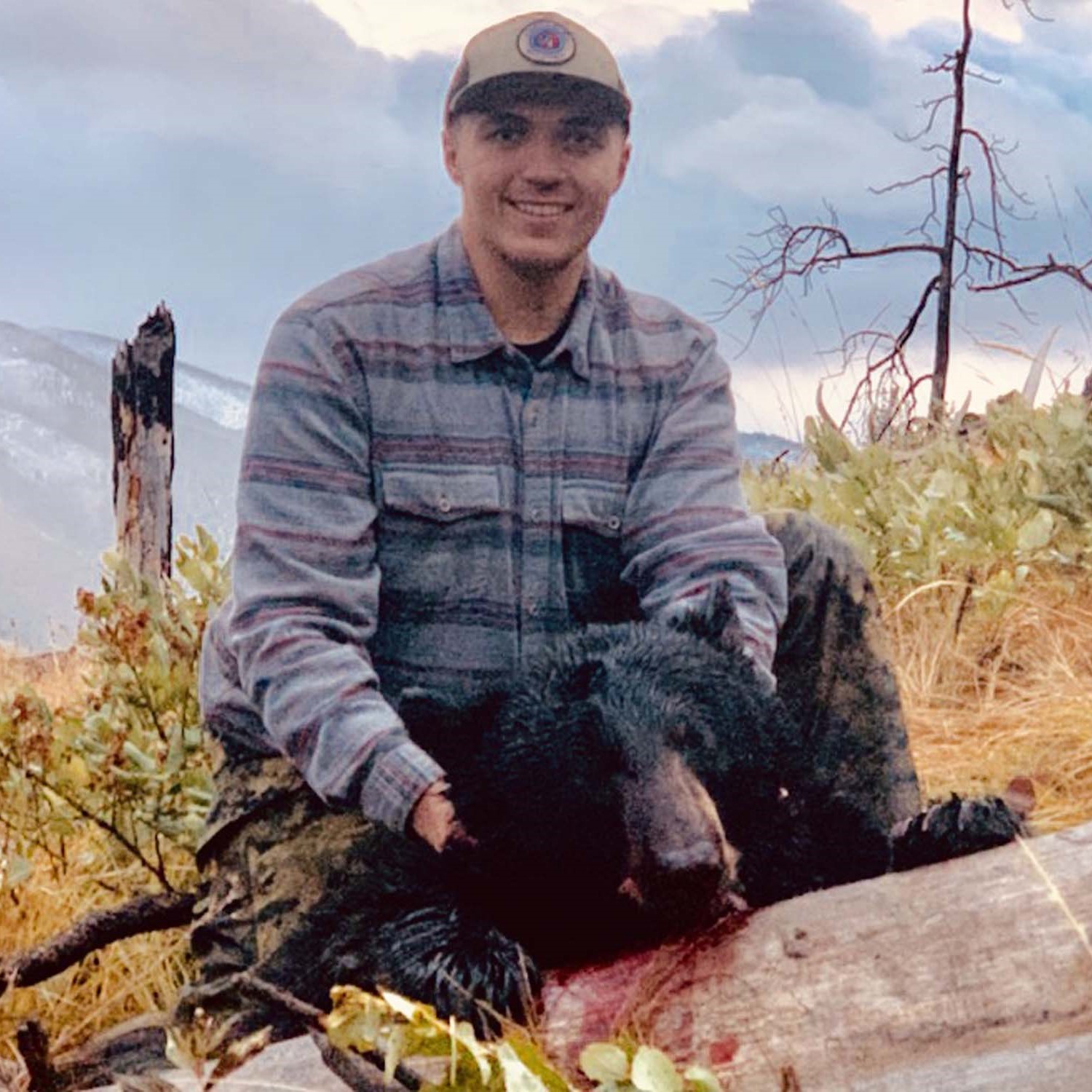 Wyoming black bear hunting guide with rifle in wilderness terrain for 4-day guided hunt