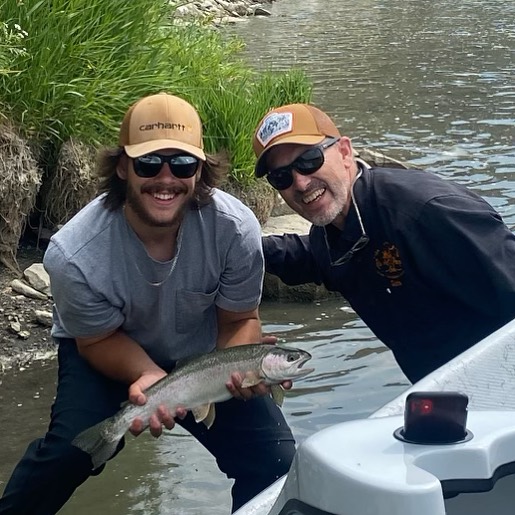 Angler holding a rainbow trout fish in Alberta, Canada