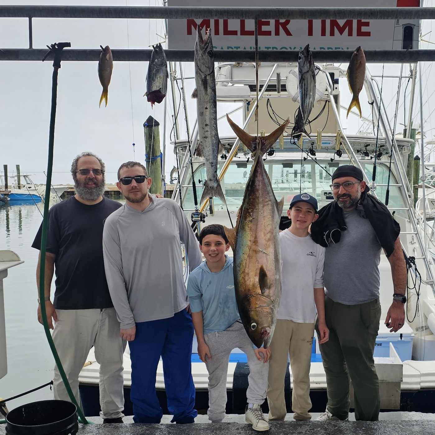 Fishing charter catch display in Islamorada FL featuring Greater Amberjack, Great Barracuda, Atlantic Bonito, and Skipjack Tuna hanging at marina dock