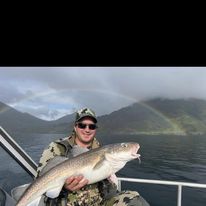 A fisherman holding a large 31-inch fish in Kodiak