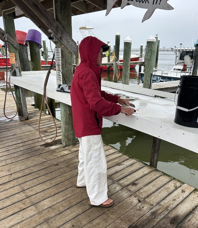 Fish cleaning station at Gulf Shores AL marina dock with boats in background