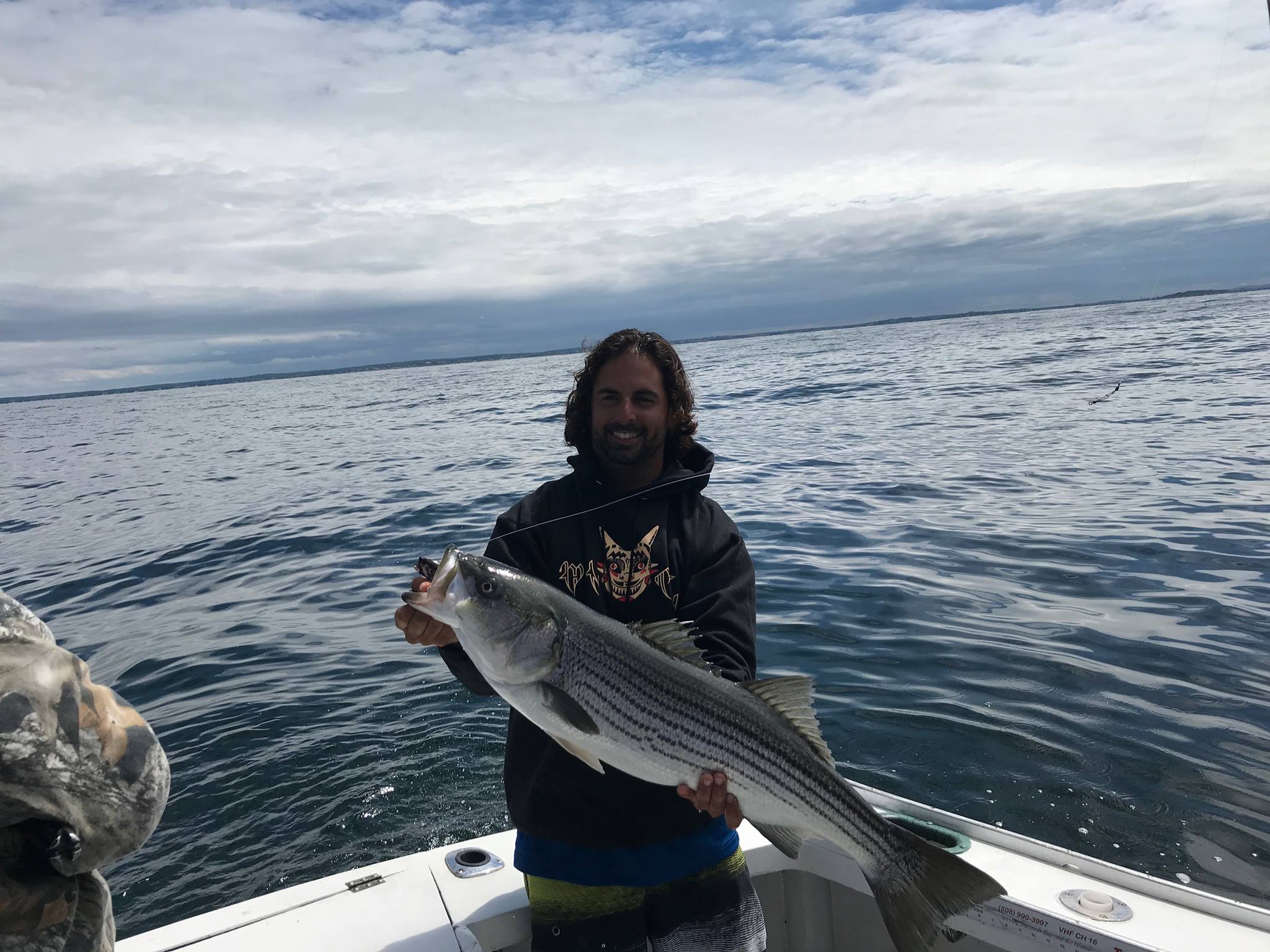 A person fishing for a striped bass in Quincy