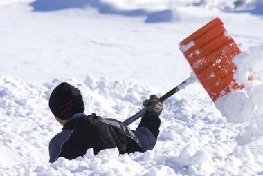 Snow shovel breaking through deep snow in Barnstable MA winter conditions