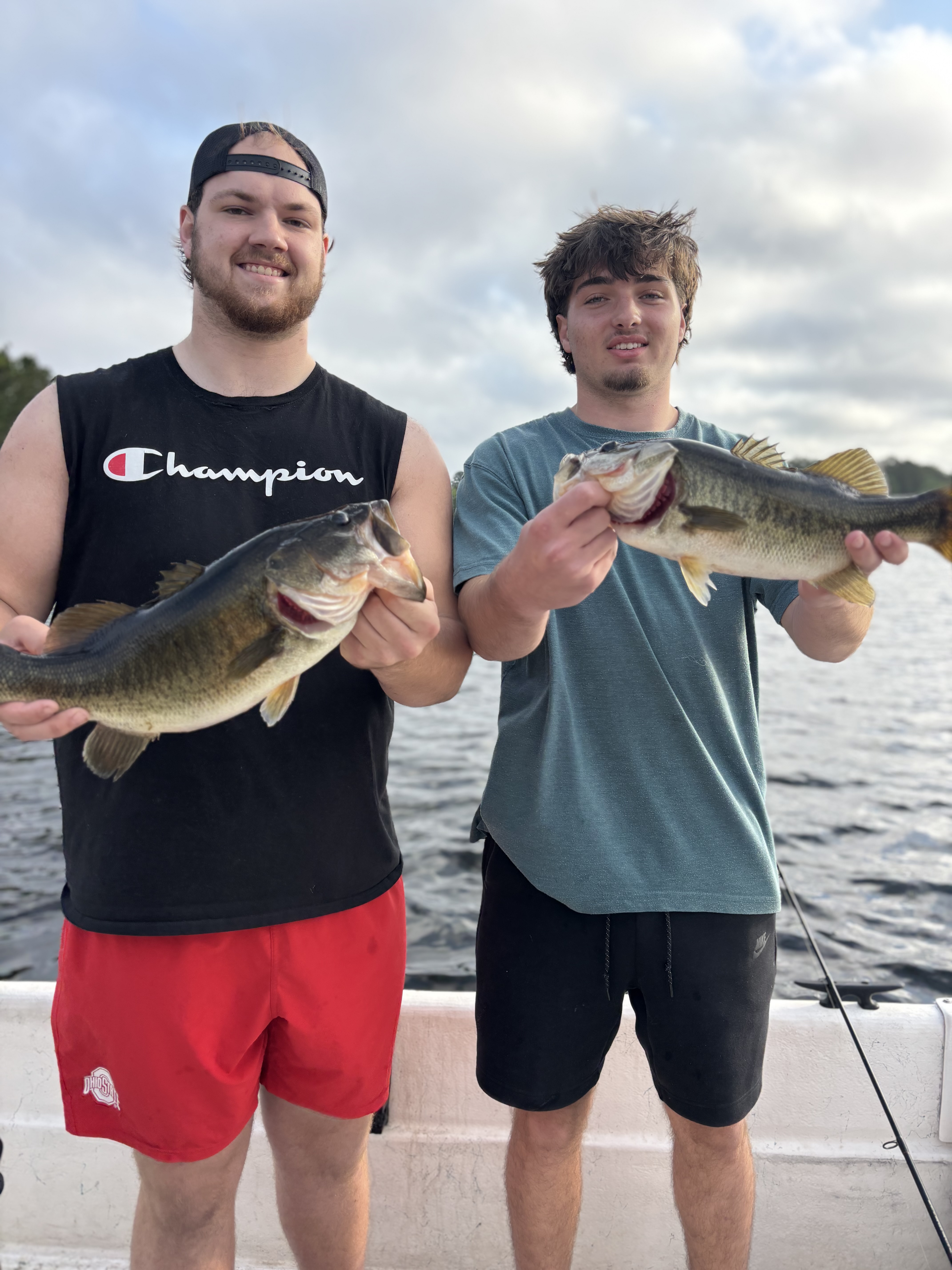 Two anglers displaying freshly caught bass while fishing in Interlachen FL