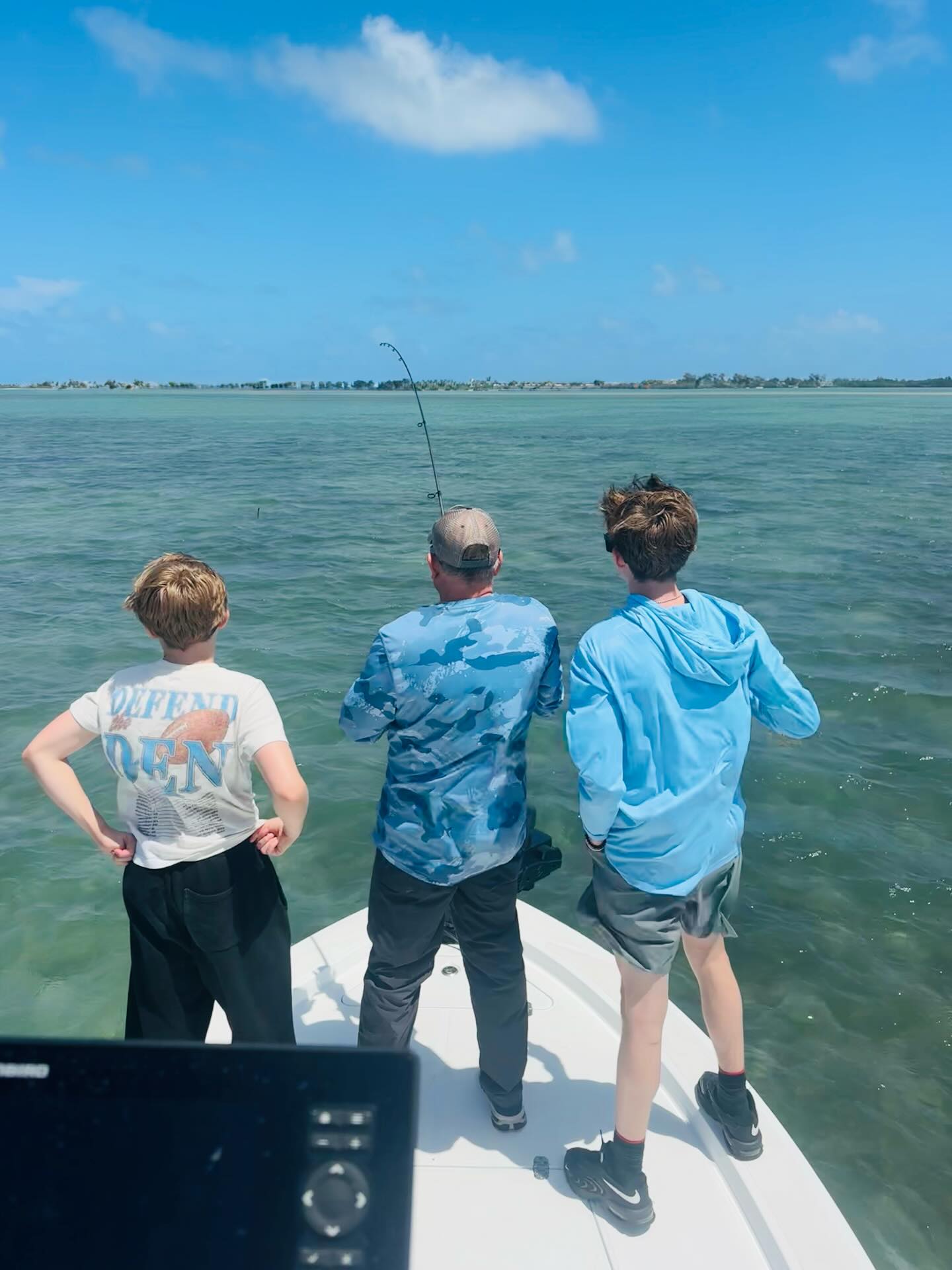 Fishing from boat bow with bent fishing rod in Jensen Beach FL waters