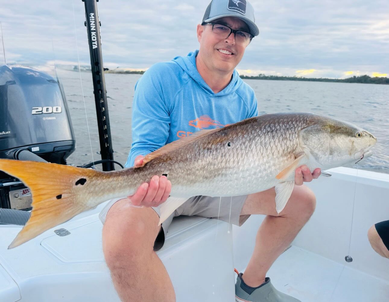 Angler holding large redfish on fishing boat in Jensen Beach FL
