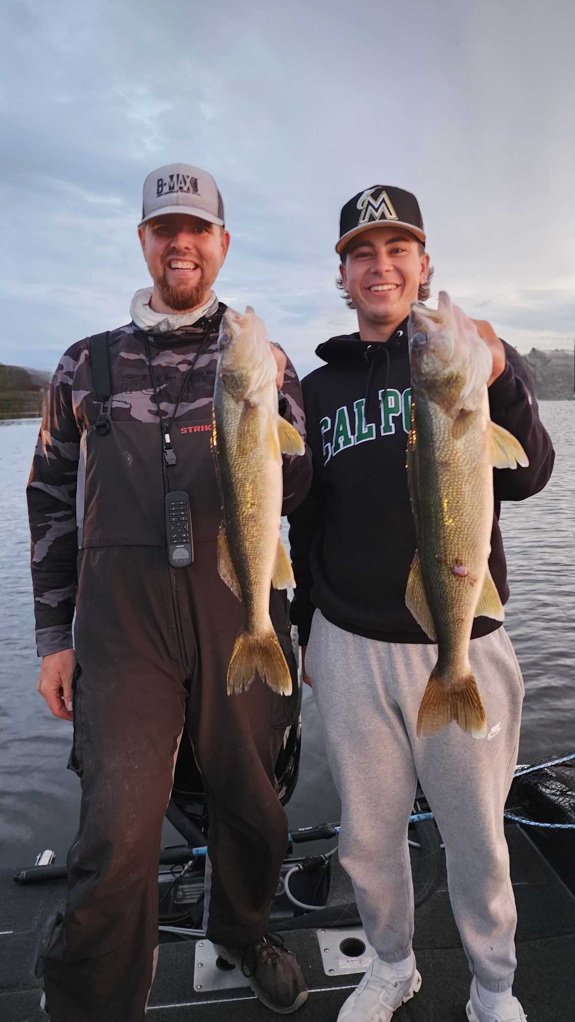 Two anglers displaying freshly caught walleye on fishing boat at Breezy Point MN