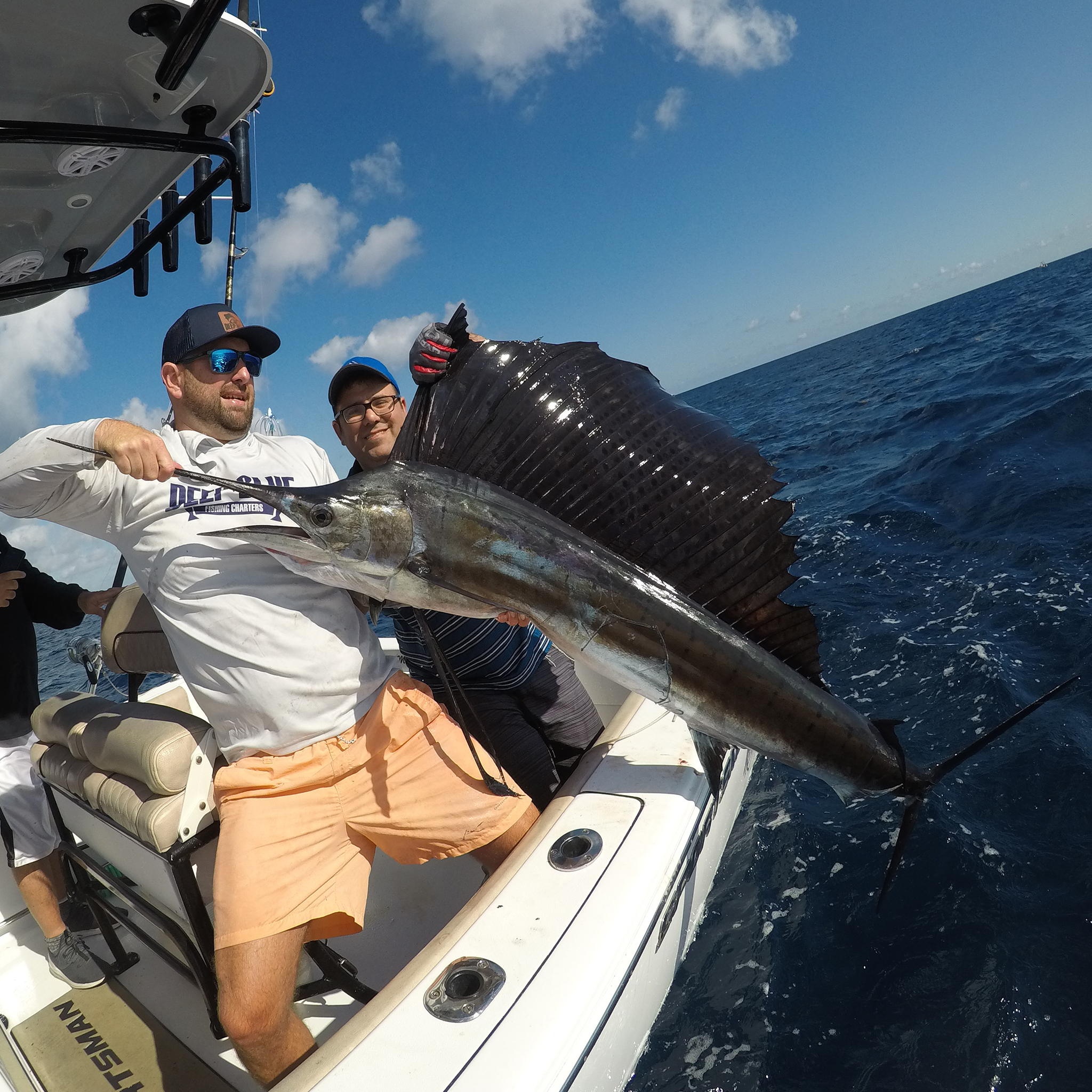 A group of 3 people fishing for an Atlantic Sailfish in Florida