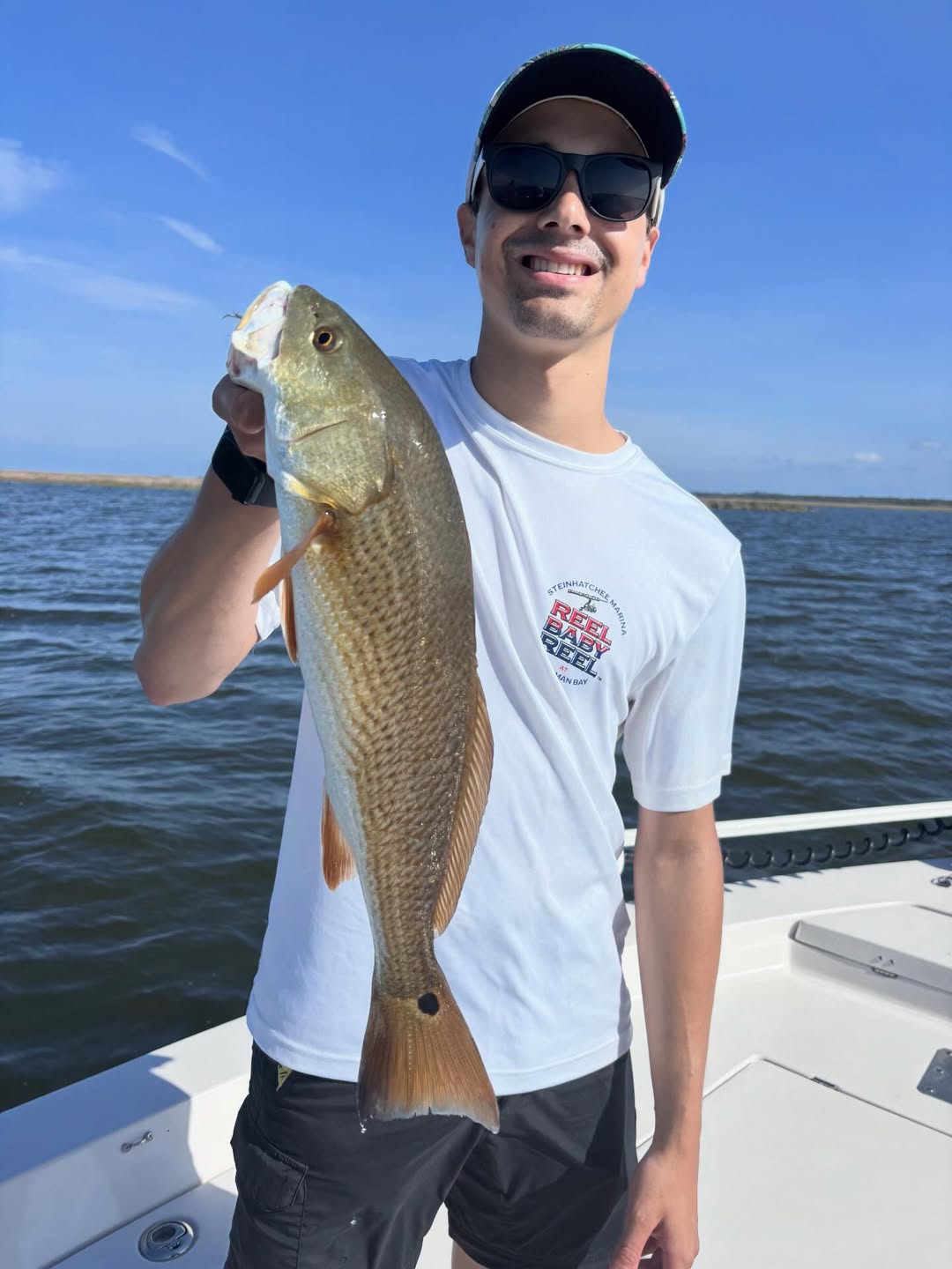 Angler holding caught redfish on fishing boat in Steinhatchee FL waters