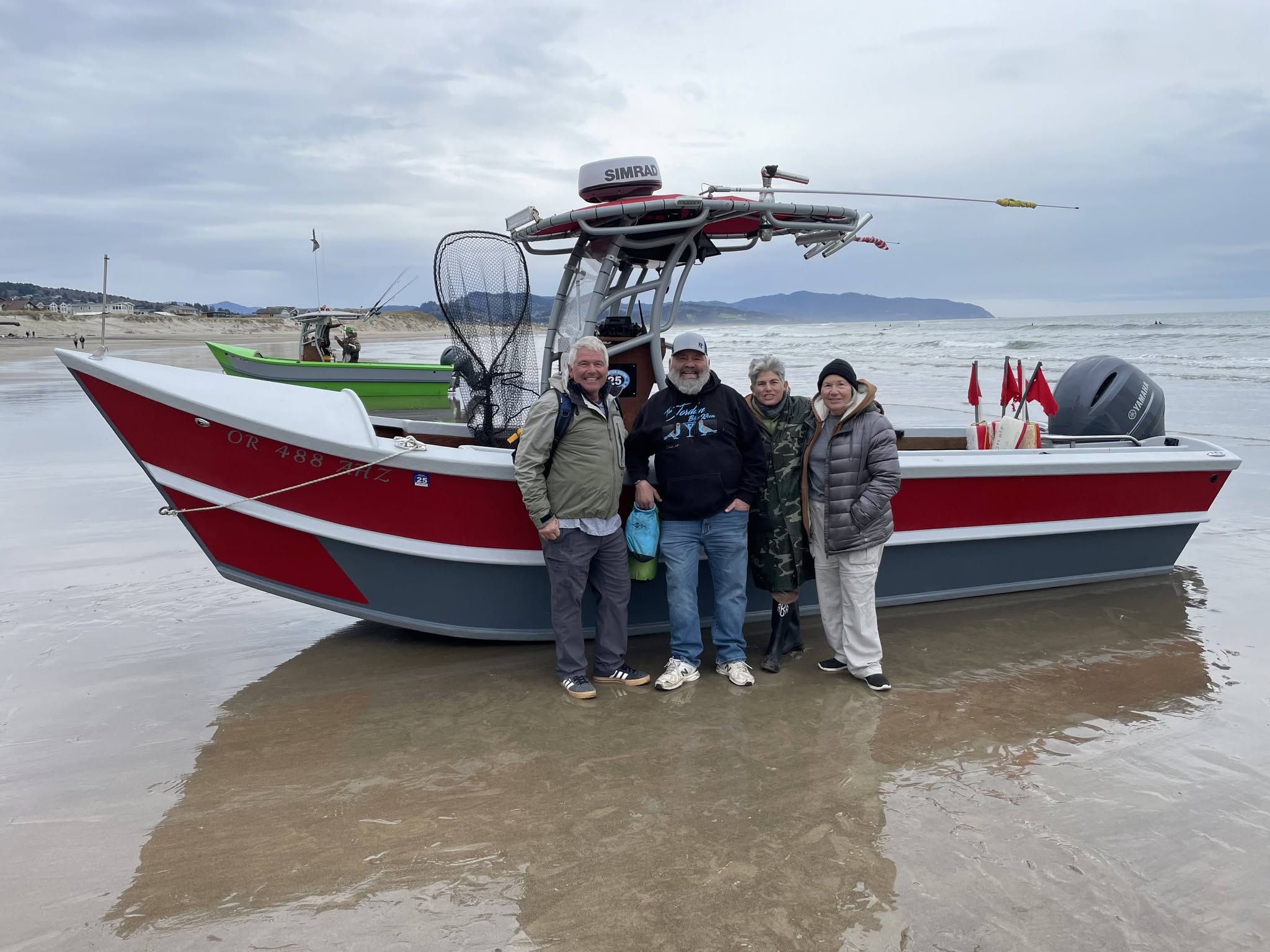 Fishing boat beached on sandy shore in Pacific City OR with fishing equipment and outrigger poles