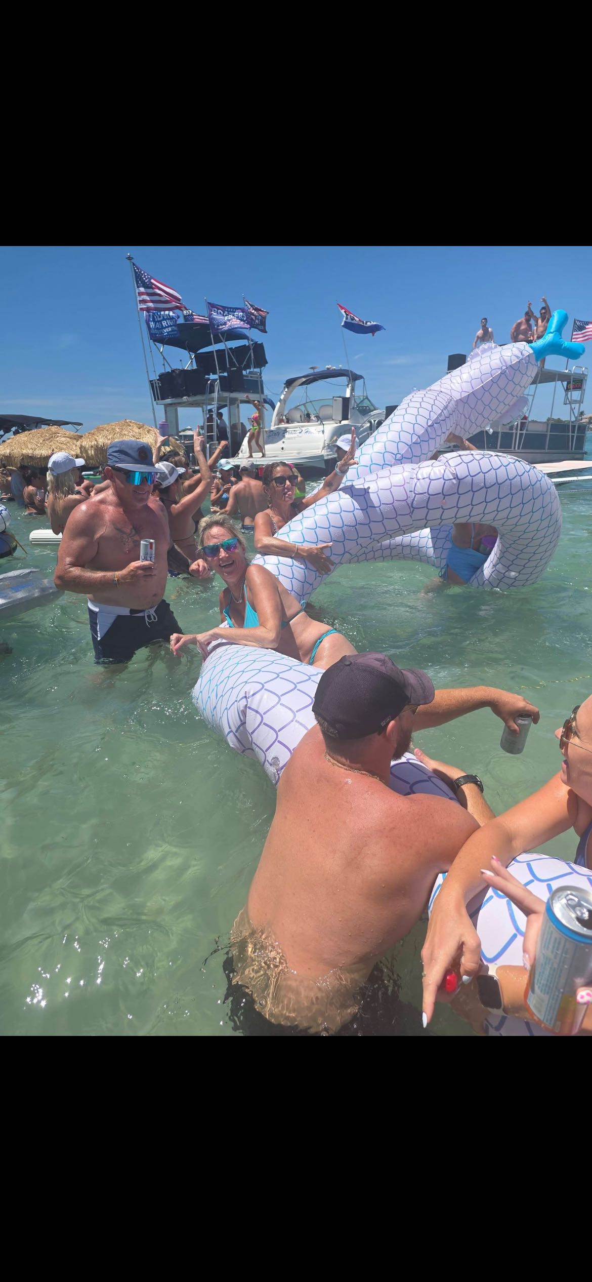 Group enjoying water activities with inflatable dragon float in clear waters near St. Petersburg FL