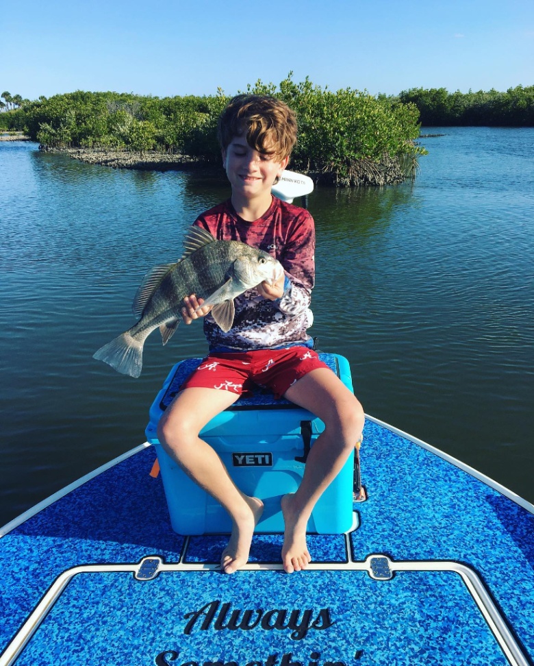 Fisherman holding a black drum fish in FL