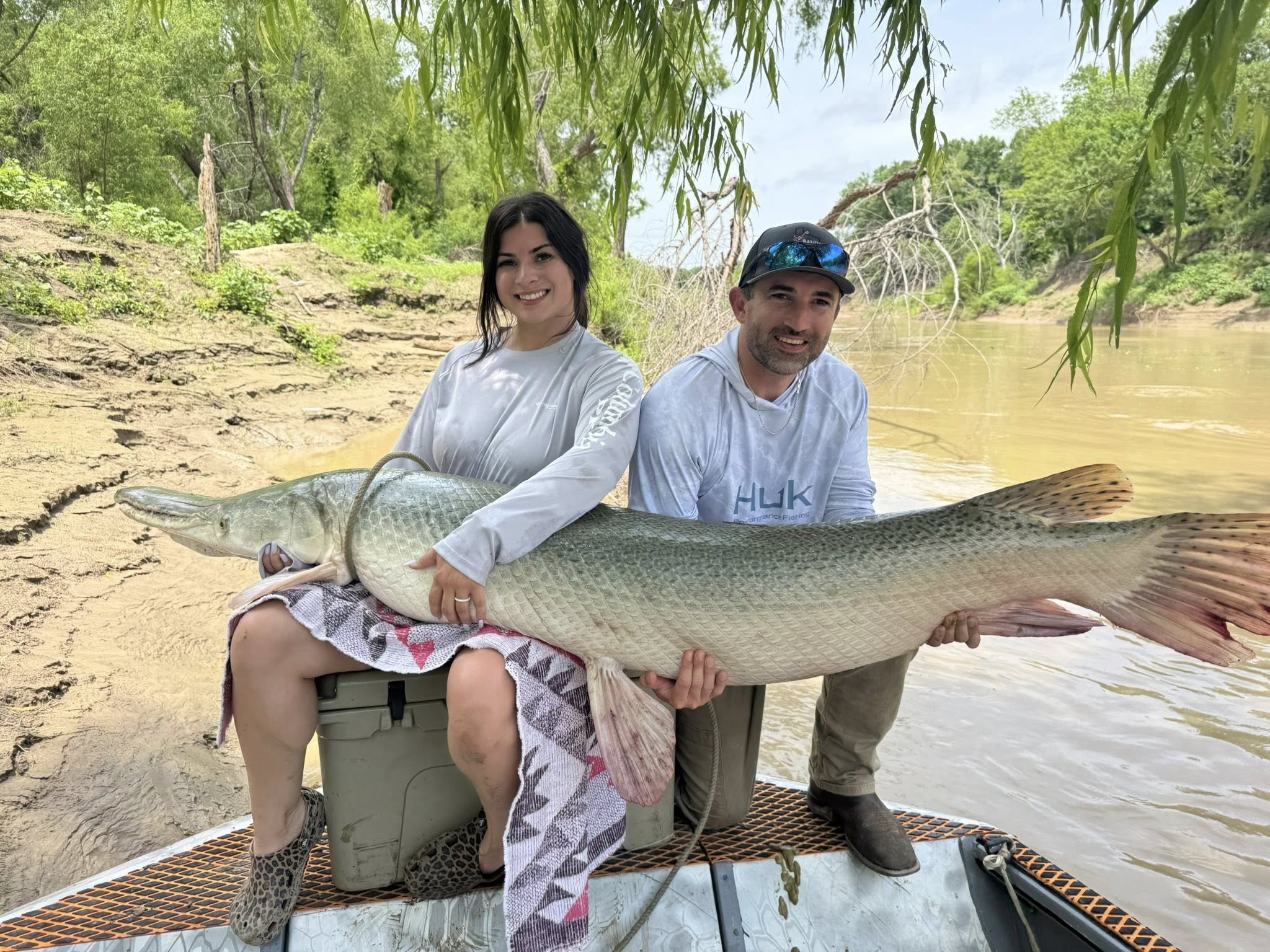 Two anglers displaying large alligator gar caught while fishing in Palestine Texas