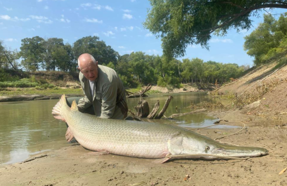 Alligator gar fishing guide boat on Texas river near Palestine with fishing equipment ready