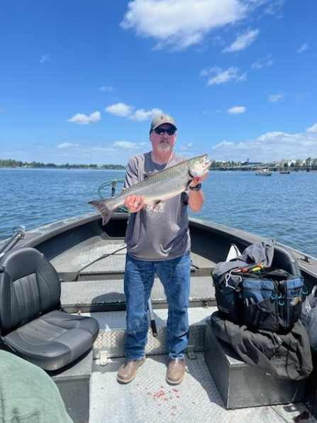 Angler holding large fish on boat in Clackamas OR waters