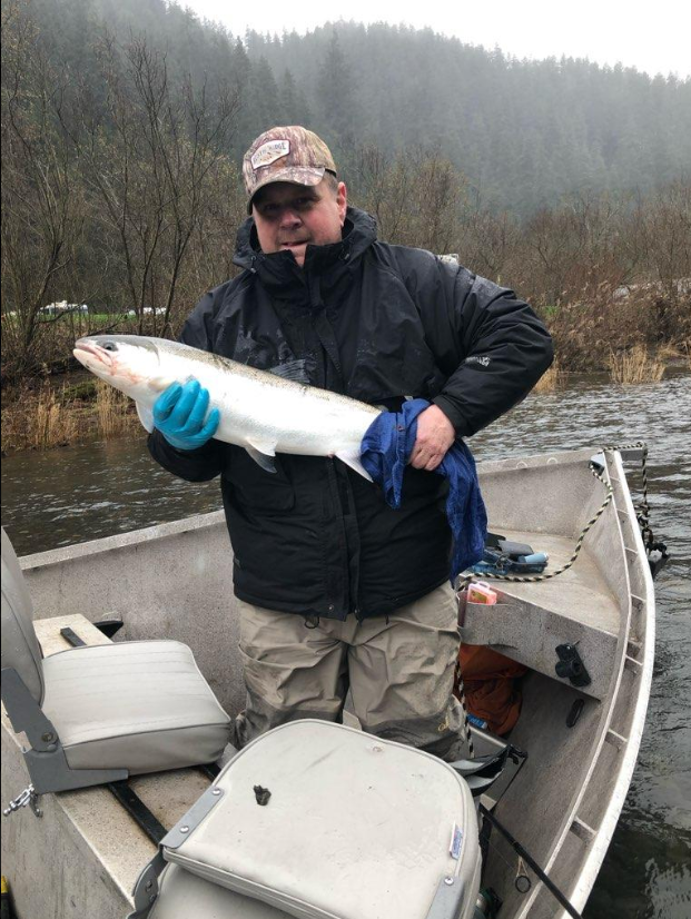 Angler holding large salmon on fishing boat in Clackamas Oregon river