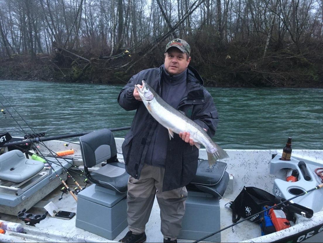 Angler holding large salmon on fishing boat in Clackamas Oregon river