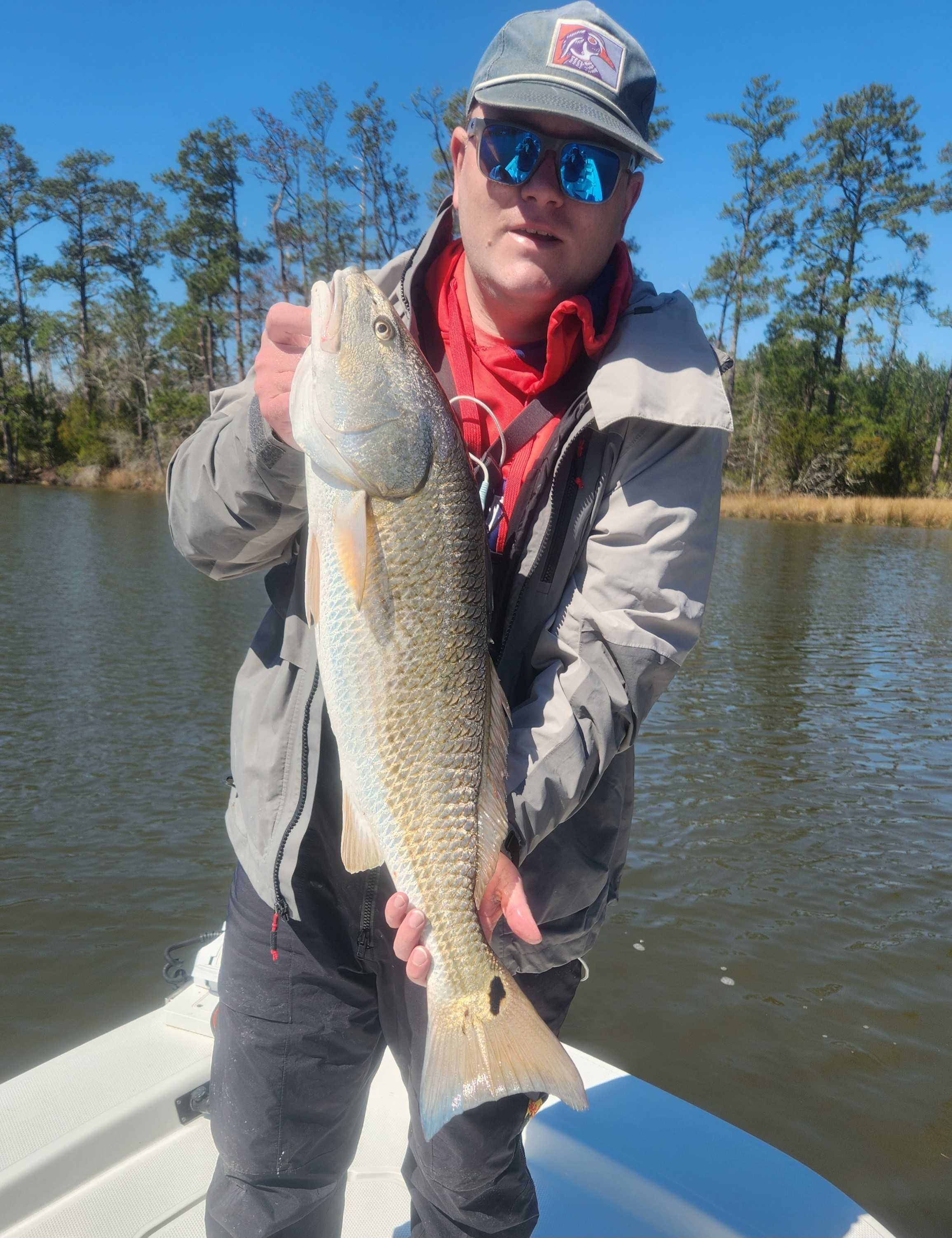 Angler holding a huge redfish in Oriental