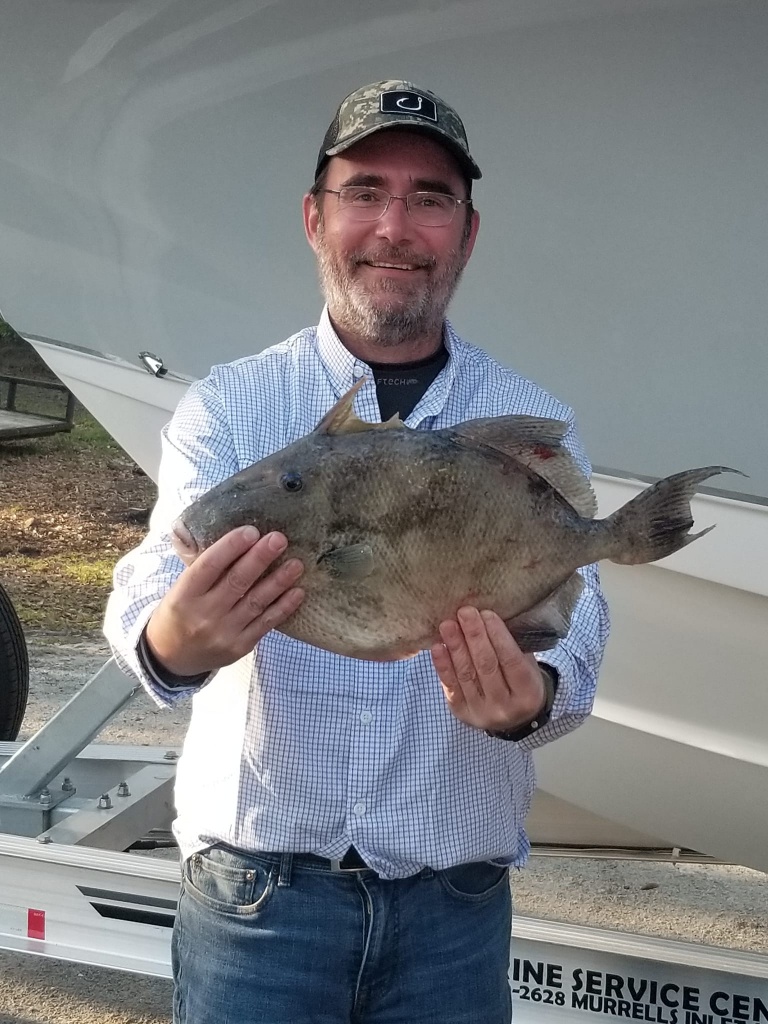 Angler catching a grey triggerfish in Little River