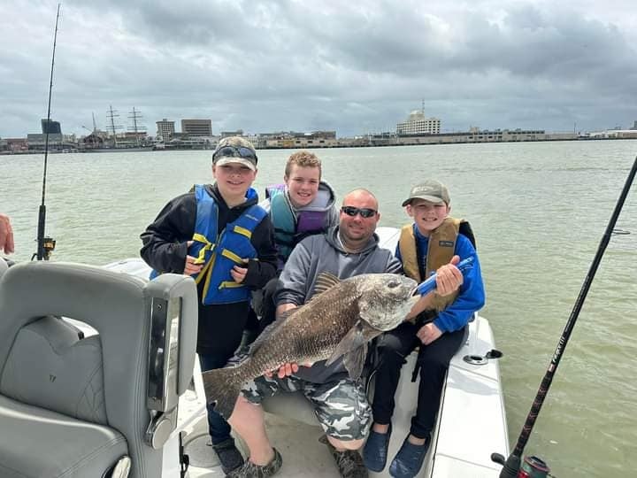 A large black drum fish caught by four people fishing in Galveston