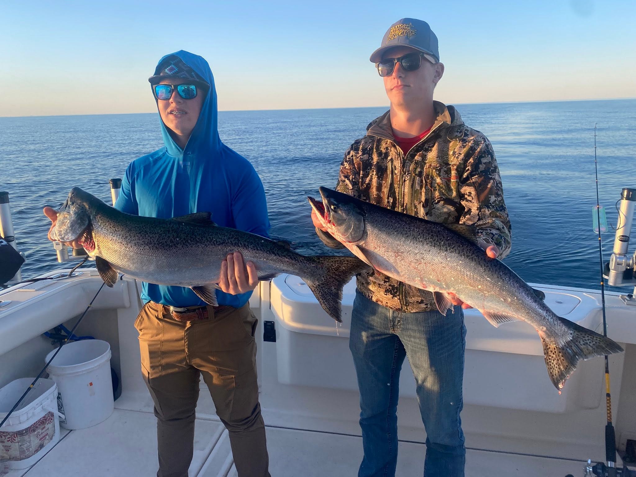 Two anglers displaying freshly caught Chinook salmon on fishing boat in Sheboygan WI